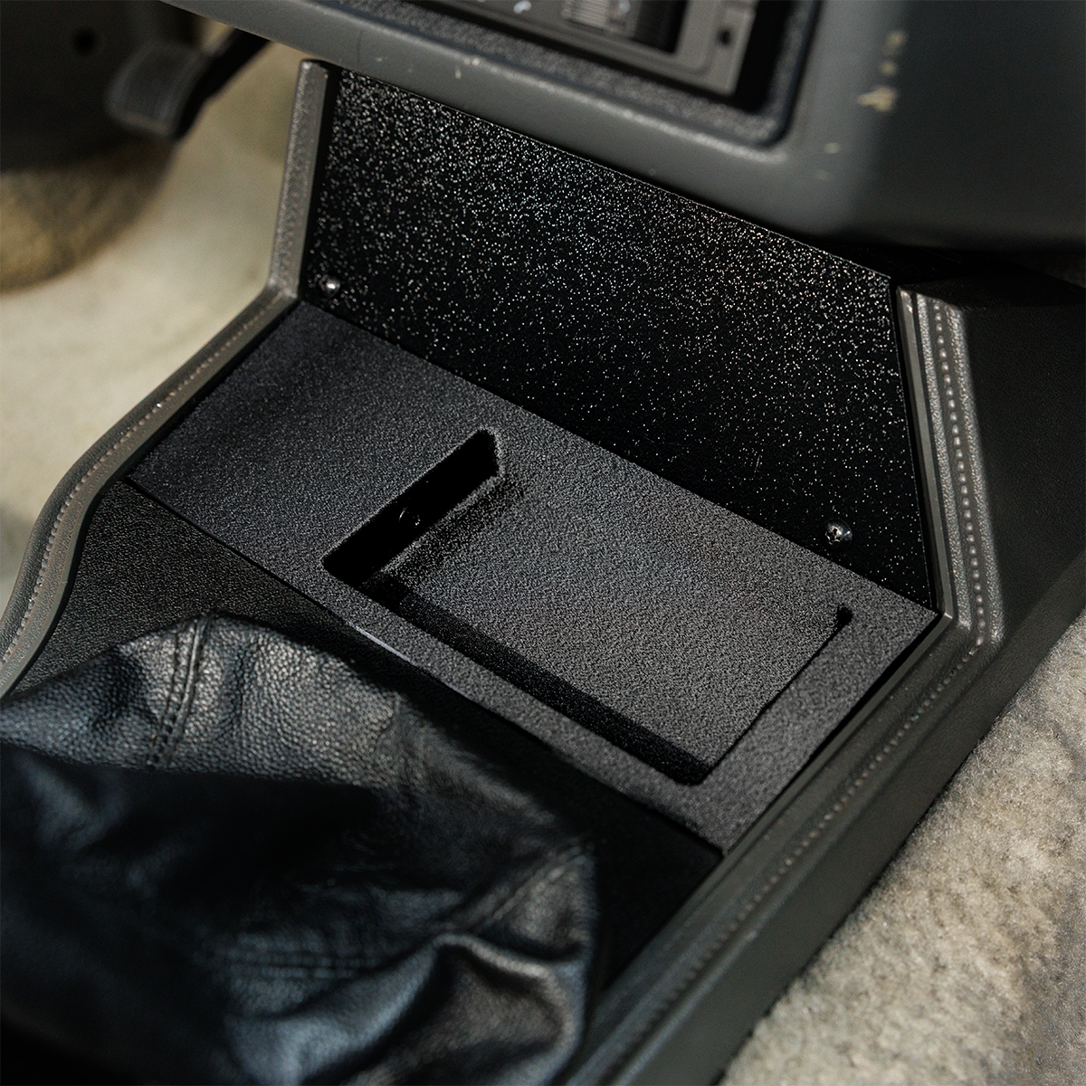Car console with a black compartment and leather jacket inside