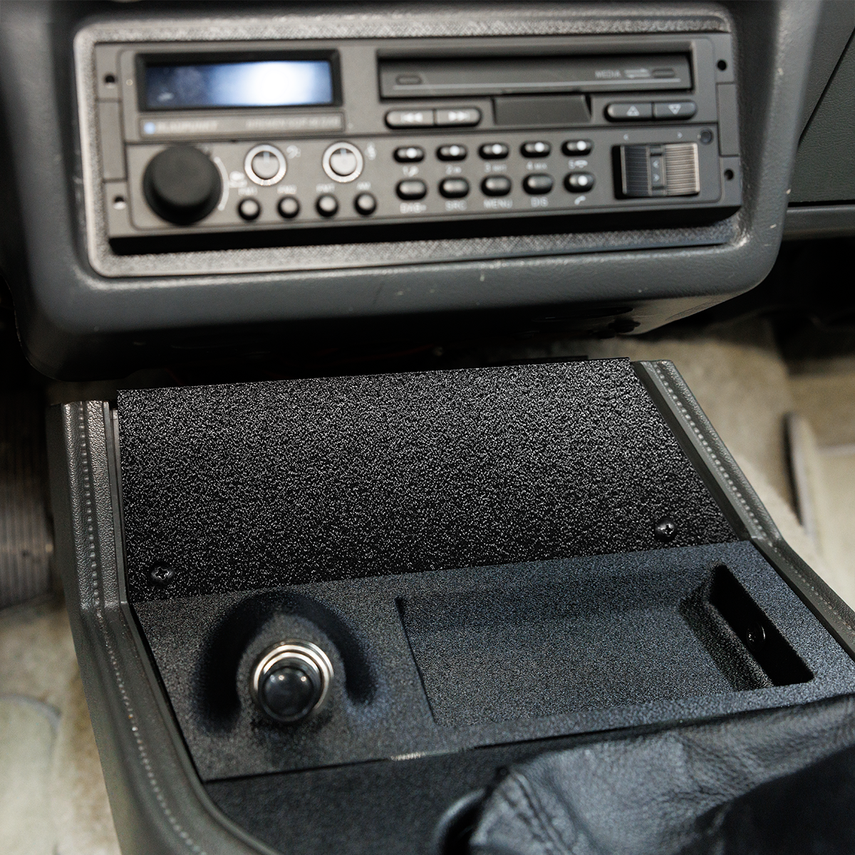 Car stereo system with a CD player and radio in a vehicle interior.