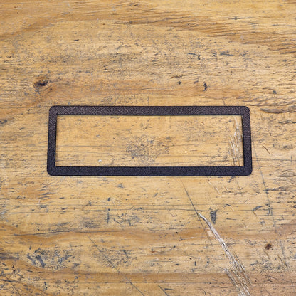 Black rectangular radio trim on a wooden surface